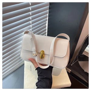 Detail of white leather shoulder bag with gold oval twist lock and minimalist design