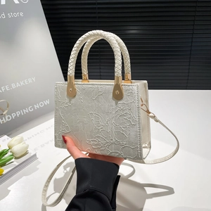 Chic cream-white crossbody bag with floral jacquard texture and braided leather handle