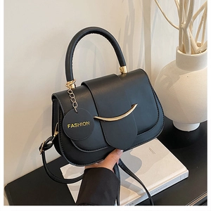 Detail der schwarzen Satteltasche aus Leder mit goldener Hardware und Schultergurt