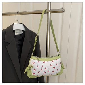 Détail du sac porté épaule imprimé cerises vert clair avec nœuds et fermeture éclair