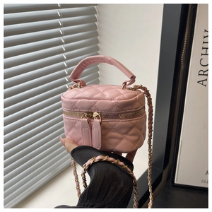 Detailed shot of a pink quilted mini box bag featuring a double zipper and chain strap