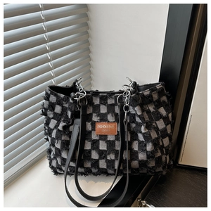 Nahaufnahme der Retro-Schachbrett-Tasche mit Fransen und silberner Ketten-Lederriemen