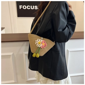 Detail of hand-woven crossbody bag featuring 3D crochet flowers and pearl clasp
