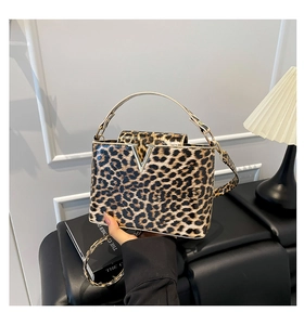 Detail of the elegant leopard print tote bag featuring a polished metallic V-shaped buckle