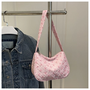 Detail of pink bow-print pleated fabric and crescent shoulder bag with silver zipper