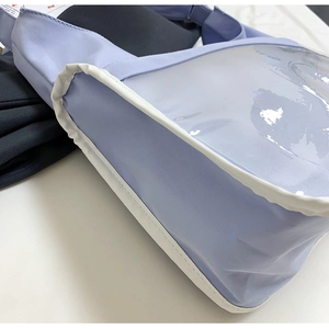 Gros plan détaillé du sac bandoulière lilas avec fenêtre PVC et coutures blanches