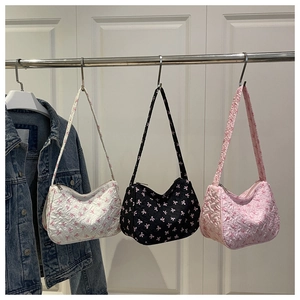Detailed texture of seersucker hobo bags with pink bow prints in three colors