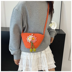 Detail of woven cotton shoulder bag with handmade 3D floral accents and pearl button