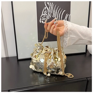 Détail du sac seau à paillettes avec chaîne dorée et deux grandes perles blanches