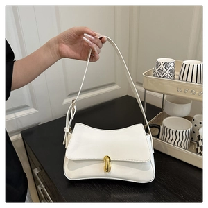 Close-up of cream underarm bag with glossy finish and gold rotary metal buckle