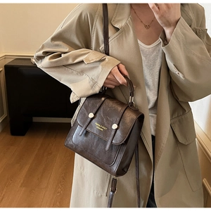 Détail d'un sac en cuir marron vintage avec boucle dorée et bandoulière réglable