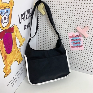 Sac bandoulière tendance en nylon noir avec liseré blanc et deux poches avant