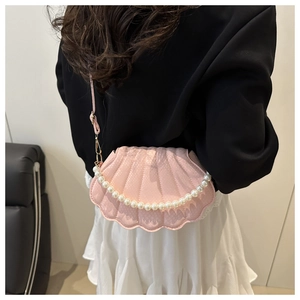 Detailed shot of pink shell crossbody bag with snake texture and pearl chain detail