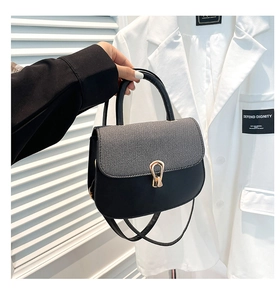 Detalle del bolso de hombro en tweed gris y cuero negro con hebilla metálica dorada