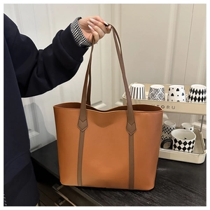 Close-up of brown faux leather tote bag with dark coffee contrast handles for commuting