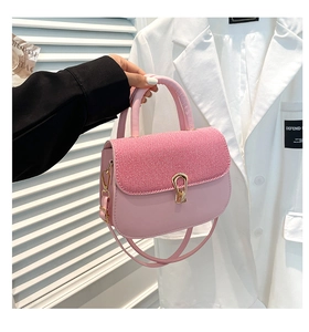 Detalle de bolso bandolera de tweed rosa con cierre de gota dorado y diseño de patchwork