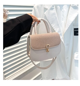 Detalle del elegante bolso cuadrado pequeño con textura y cierre de gota dorada