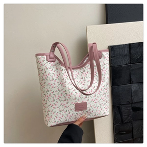 Detail view of floral canvas tote bag with pink leather trim and fashion tag decoration