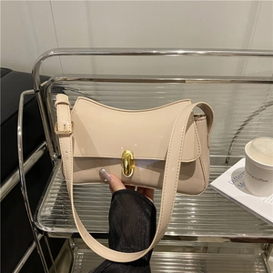 Chic beige underarm bag in glossy patent leather with adjustable strap and gold clasp