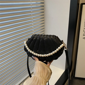 Elegant black shell-shaped handbag with snake pattern texture and pearl handle