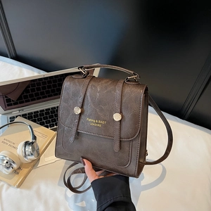 Sac à dos vintage en cuir marron avec boucle dorée et poignée en scène de vie
