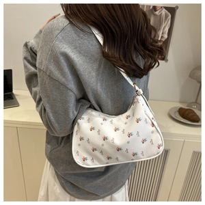 Detail of trendy cream-white underarm bag with floral print and adjustable shoulder strap