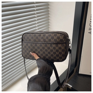Detail of vintage brown monogram shoulder bag with M pattern and zipper closure