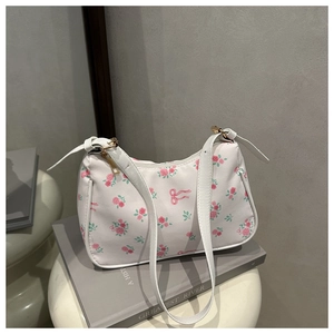 Détail du sac à bandoulière baguette blanc avec motifs floraux roses et zip doré