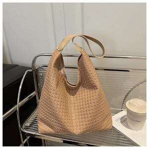 Gros plan sur la texture tissée beige du sac cabas au style urbain minimaliste