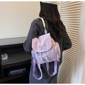 Detailansicht des lila Rucksacks mit Ai Mei Stickerei und Kordelzug mit Perlen