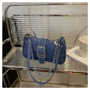 Detailed close-up of blue denim baguette bag with silver buckle and contrast stitching