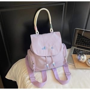 Close-up of lilac canvas backpack featuring drawstring closure and Ai Mei embroidery