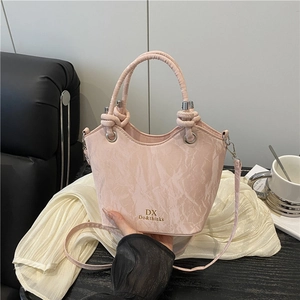 Pale pink textured bucket bag with top handle and crossbody strap for women