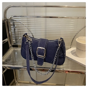Detail view of denim shoulder bag with silver metal buckle and contrast stitching