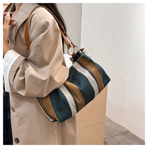 Close-up of green and brown vertical stripe canvas tote with premium leather shoulder strap
