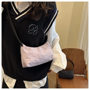 Detail of light purple nylon crossbody bag with casual crinkle texture and slim black strap