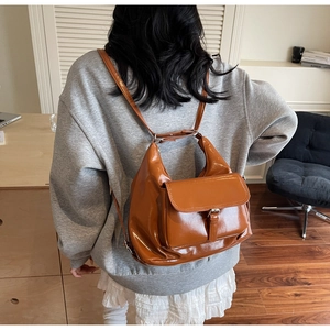 Rear view of caramel brown glossy leather tote bag shown on model for daily commuting