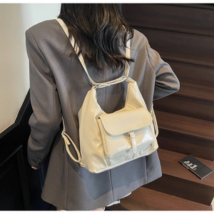 Detail of a creamy white soft leather hobo tote showing adjustable straps and front pocket