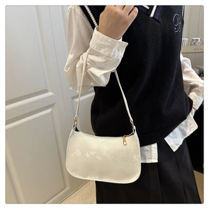 Detail of white faux leather hobo bag with snake texture and golden top zipper