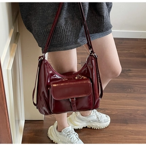 Deep burgundy glossy leather tote bag with functional front buckle pocket and adjustable strap