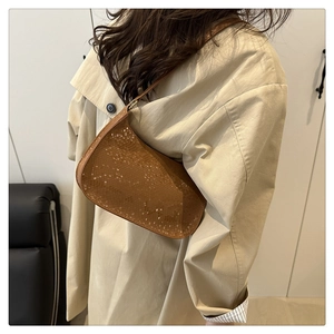 Brown snakeskin pattern baguette bag worn over the shoulder with a beige trench coat