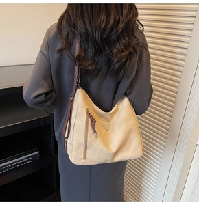 Détail d'un sac hobo beige avec bandoulière réglable et tirette de fermeture tressée