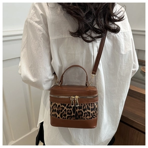 Model view of leopard print crossbody bag showing vintage cylinder shape and leather texture