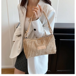 Détail d'un sac cabas en velours côtelé beige avec poignée nouée et larges rayures