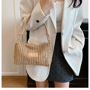 Détail du sac à bandoulière en velours côtelé beige montrant la texture plissée et le zip