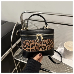 Detail of leopard print contrast bucket bag with gold zippers and black leather top handle