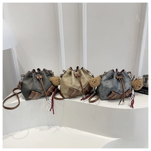 Detailed trio of canvas bucket bags in grey and khaki with leather trim and bear charms