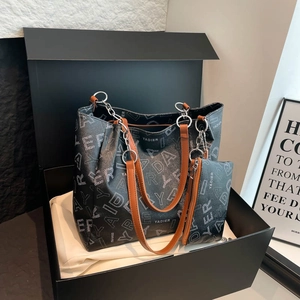 Large black letter print tote bag with brown handles and chain in a luxury gift box