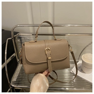 Vue détaillée du sac à main en cuir grainé kaki avec fermoir en métal doré sur étagère