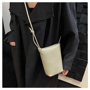 Close-up of champagne lychee pattern leather crossbody phone bag with knot strap